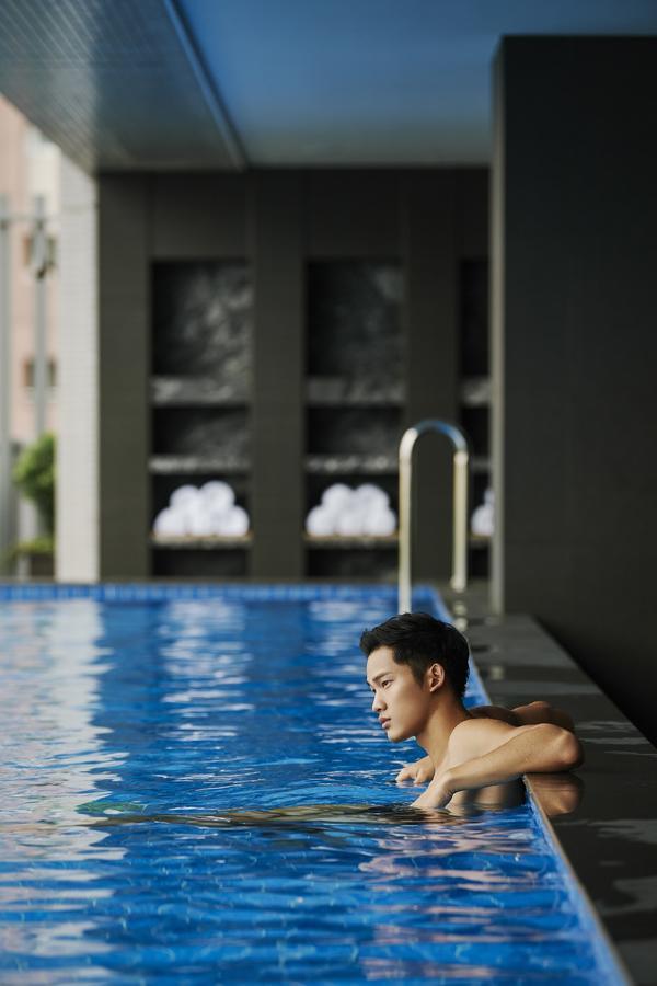 Hotel Silks Club Kaohsiung Esterno foto A man swimming in a pool